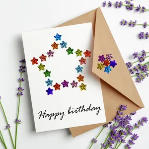 Detalle de pegatinas de estrellas brillantes de colores en una tarjeta de cumpleaños blanca