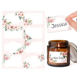 Detail showing floral blank sticker on a candle jar and a hand peeling a name tag label
