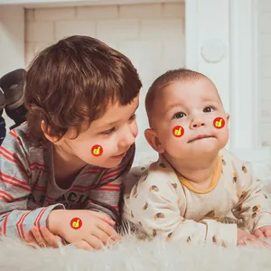 Détail d'autocollants de récompense pouce levé appliqués sur la peau d'enfants à l'école