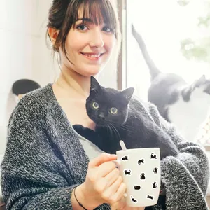 Primer plano detallado de lindas pegatinas de gatos negros decorando una taza de cerámica