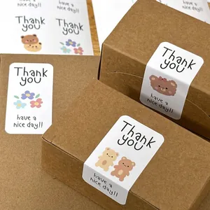Primer plano de lindas pegatinas 'Thank you' de ositos en cajas de regalo de papel kraft