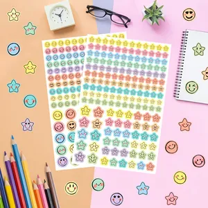 Detailed view of colorful macaron pastel emoji and star sticker sheets for scrapbooks