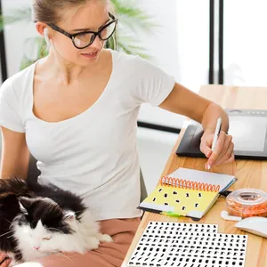 Primer plano de lindos adhesivos de gatos negros decorando un cuaderno de notas