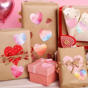 Pegatinas decorativas con forma de corazón sobre cajas de regalo de papel kraft marrón