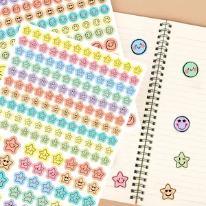 Detailed view of colorful macaron smiley face and star stickers for scrapbooking.