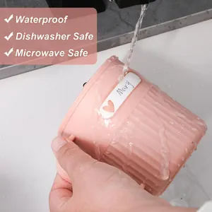 Close-up of waterproof personalized name label sticker on a pink cup under running water