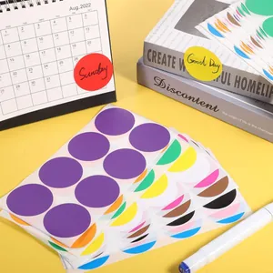 Dettaglio di grandi bollini adesivi colorati da 5cm per organizzare articoli da ufficio.