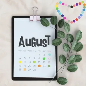 Close-up of colorful round dot stickers used for marking dates on an August calendar page.