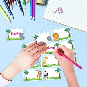 Detail view of a child writing a name on a colorful animal-themed writable sticker.