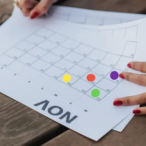 Close-up detail of colorful round dot stickers being used for marking a November calendar page.