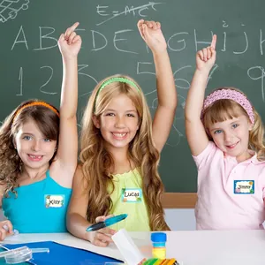 Children wearing ocean themed writable name stickers in a classroom setting