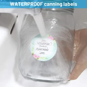 Close-up of waterproof round canning label on a glass jar under running water
