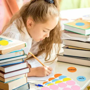 Dettaglio di adesivi tondi colorati da 5 cm usati da uno studente per segnare i libri