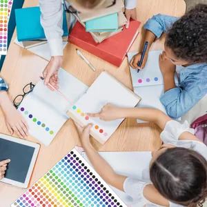 Children using colorful round dot stickers for organizing school notebooks