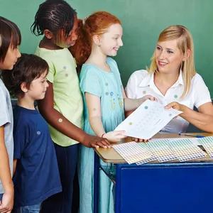 Teacher rewarding students with colorful smiley face stickers in a bright classroom