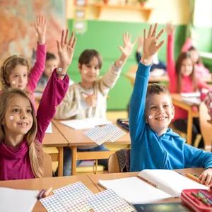 Λεπτομερής προβολή παιδιών που χρησιμοποιούν πολύχρωμα αυτοκόλλητα επιβράβευσης στην τάξη