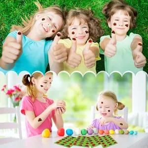 Children showing creative ladybug stickers applied on faces and hands in a sunny outdoor setting