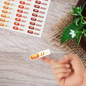 Detalle de una pegatina de nivel de picante sostenida con la punta de un dedo.