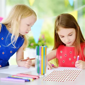 Primer plano de niñas jugando con pegatinas decorativas de frutas para manualidades