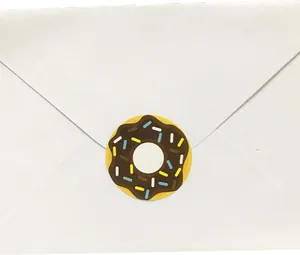 Detailed view of a chocolate donut sticker sealing a plain white paper envelope