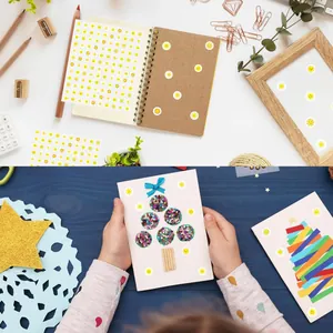 Application of mini sun smiley face stickers on kids' handmade craft card and notebook.