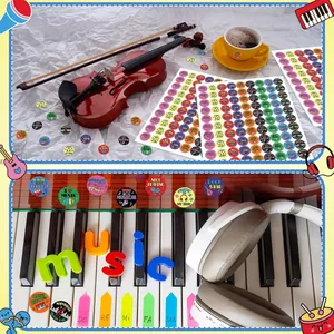 Détail d'autocollants musicaux colorés sur un clavier de piano et un casque audio