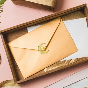 Detailed view of a golden star and moon foil sticker sealing a gold envelope