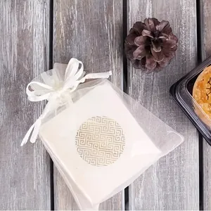 Detail view of gold geometric round seal sticker on gift packaging in a mesh bag.