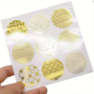 Close-up view of nine gold foil round envelope seals with diverse elegant metallic patterns