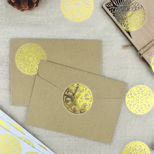Vue détaillée d'autocollants mandala dorés scellant des enveloppes en papier kraft.