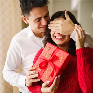 Detail showing gold foil heart stickers applied on a red gift box for a romantic scene