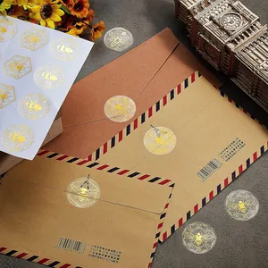Close-up of gold foil bee stickers applied on vintage airmail envelopes