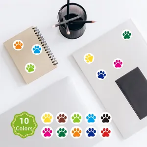 Detail view of 10 vibrant colorful paw print reward stickers on office accessories