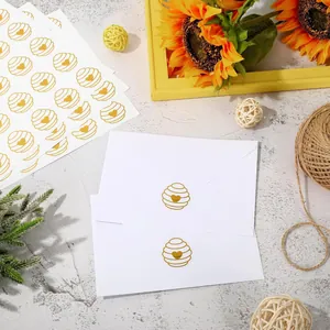 Gold foil heart honeycomb seal stickers applied on white envelopes for wedding invitations