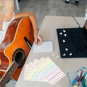 Colorful musical note stickers decorating a laptop and notebook in a lifestyle setting