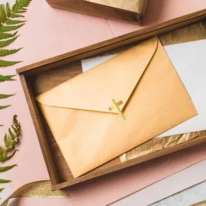 Macro view of an elegant golden cross foil seal sticker on a gold invitation envelope