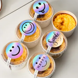 Close-up view of 5cm laser holographic smiley face stickers on bakery dessert cups packaging