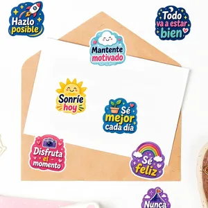 Close-up detail of various colorful Spanish motivational stickers arranged on a white envelope