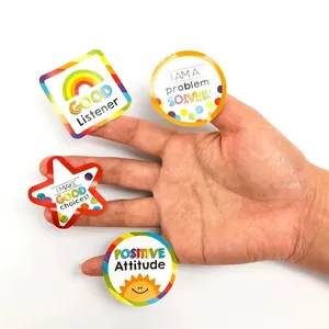Detailed macro view of colorful cartoon reward stickers held on fingers for scale demo