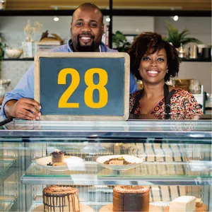 Large yellow number 28 vinyl sticker on chalkboard for restaurant table identification.