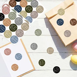 Detailed view of circular Spanish Bible verse stickers on gift bag and notebook