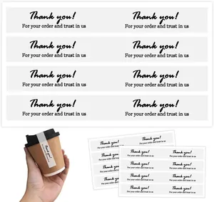 Adhesive "Thank You" seals on a coffee cup lid for spill-proof takeout packaging