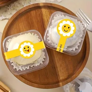 Nahaufnahme von niedlichen gelben Sonnenblumen-Smileys als Siegelaufkleber für Dessertboxen