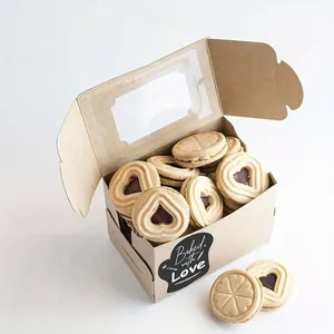 Close-up view of a black 'Baked with Love' adhesive sealing sticker on a kraft gift box