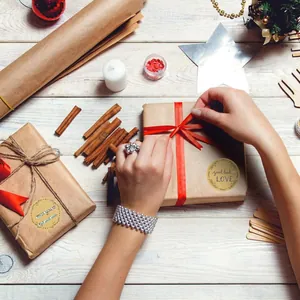 Macro view of circular kraft paper stickers with floral designs on wrapped gift boxes