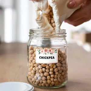 Detail view of a floral wreath label sticker applied to a glass chickpea storage jar