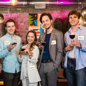 Group of friends using writable gold-stamped name tag stickers at a social party
