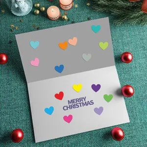 Detalle de pegatinas de colores con forma de corazón en una tarjeta de Navidad.