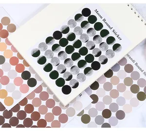 Vista de cerca de varias hojas de pegatinas circulares de colores Morandi