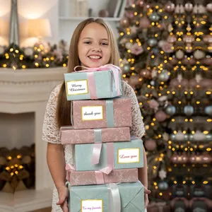 Detailed view of elegant bronzing name stickers used on stacked Christmas gift boxes